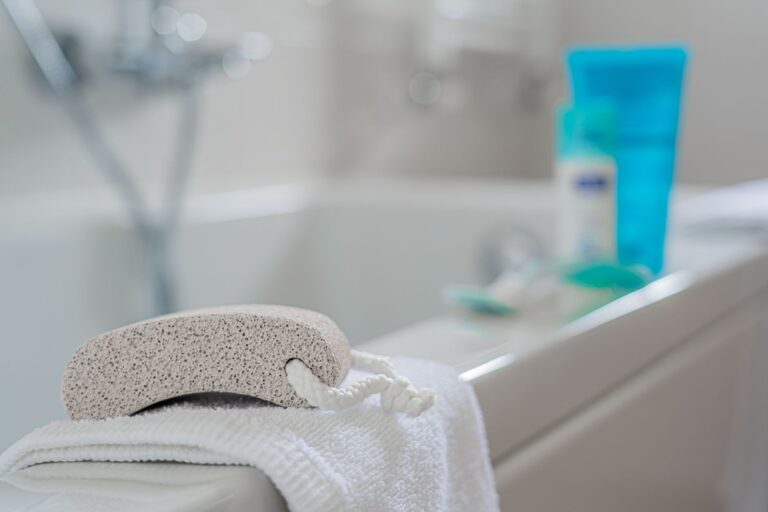 Pierre ponce posée sur une serviette blanche près d'une baignoire, pour la corne aux pieds