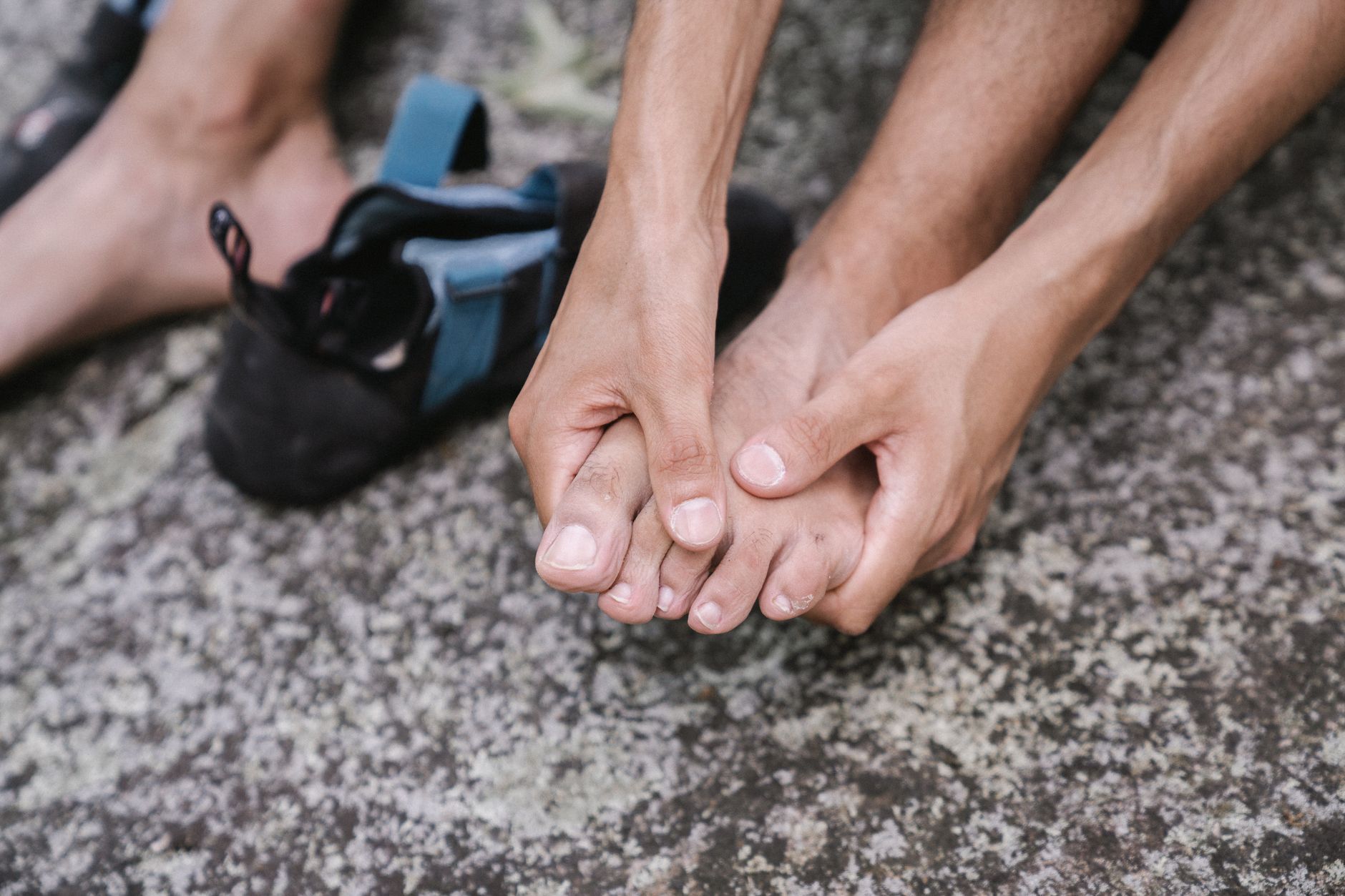 Une personne tient son pied au sol après une douleur au gros orteil